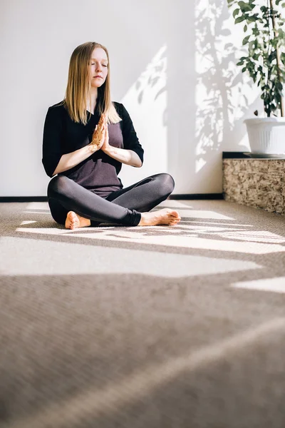 Young girl sitting on the floor in the pose of meditation — Stock Photo, Image