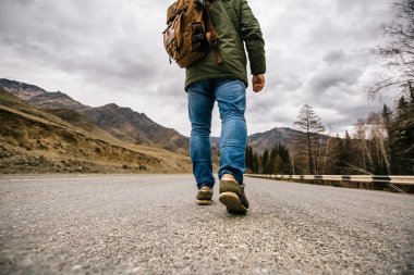 bir insan bir dağ yolda yürüyor.