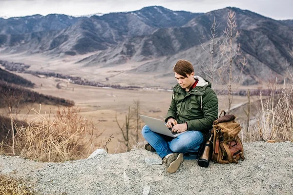 Homme avec ordinateur portable sur le fond de paysages de montagne — Photo