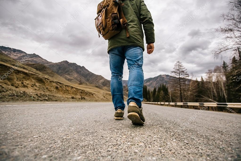 Un uomo cammina su una strada di montagna . Foto Stock Foto