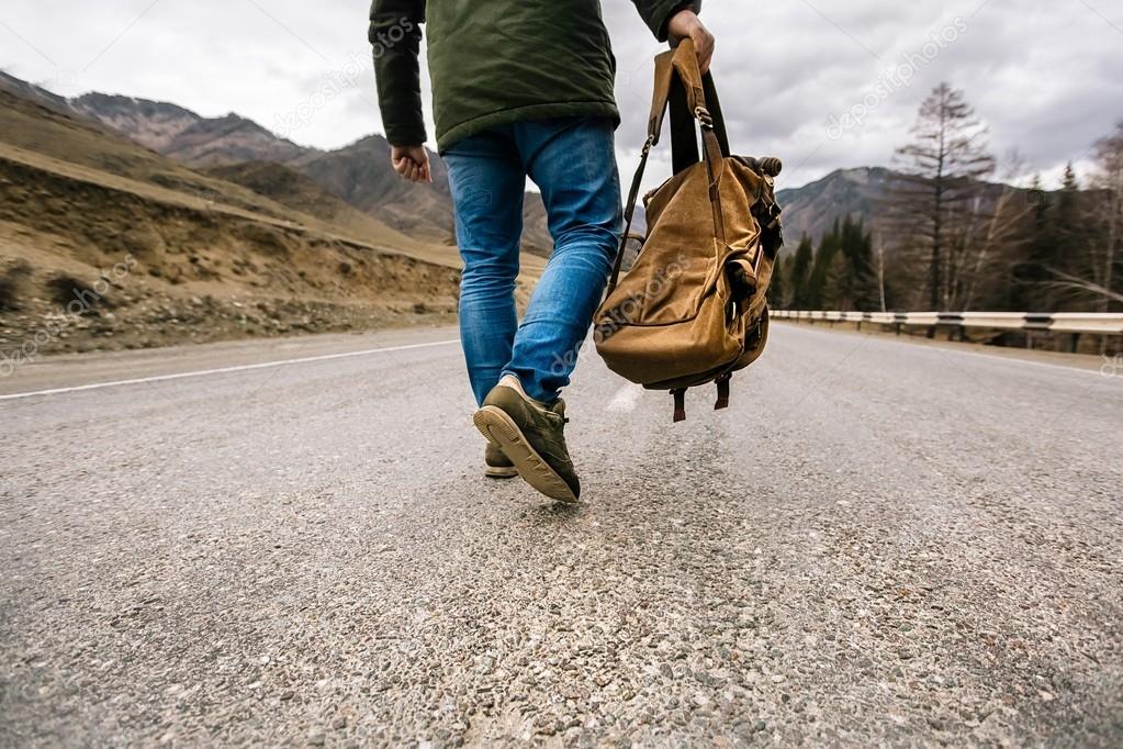 Man with backpack walking down a road Stock Photo by ©E_Serebryakova 109893652