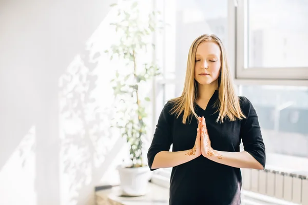 Junges Mädchen mit blonden Haaren in einem Raum beim Meditieren — Stockfoto