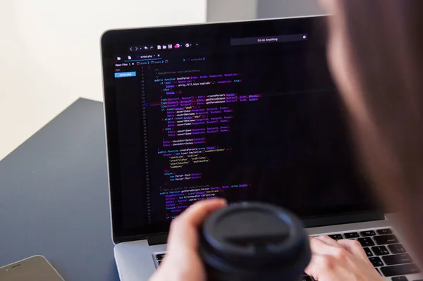 Un programador codificando en un ordenador portátil en el lugar de trabajo — Foto de Stock