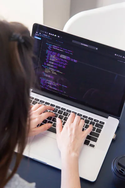 A programmer coding on a laptop in the workplace — Stock Photo, Image