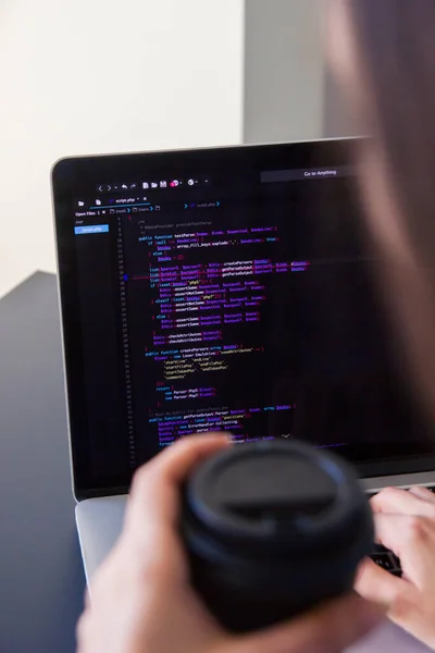 Un programador codificando en un ordenador portátil en el lugar de trabajo — Foto de Stock