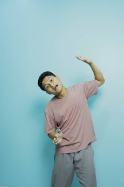 Beyaz arka planda, kısa saçlı ve şaşırmış yüzlü genç Asyalı adam.