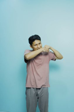 Genç adam elini gösteriyor..