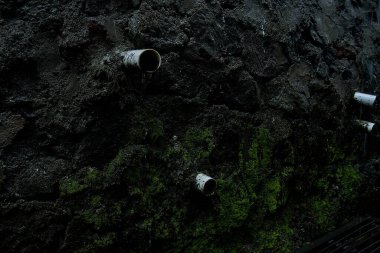 Siyah arka planı olan eski paslı demir boru.