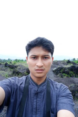 Sırt çantası ve siyah bir geçmişi olan Asyalı genç bir adam.