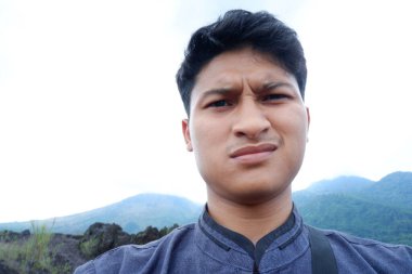 Genç turistin portresi dağlarla kameraya bakıyor.