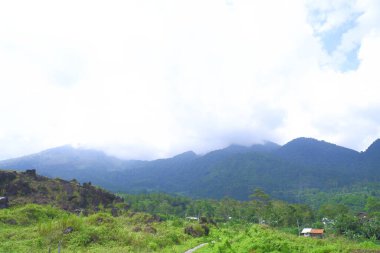 Bulutlu ve mavi gökyüzü olan dağ manzarası