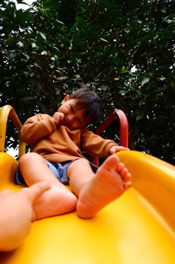 Küçük çocuk oyun alanında oynuyor.