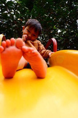 Küçük bebek çocuk oyun alanında oynuyor.