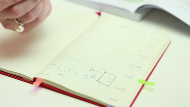 Женщина пишет в дневнике процент цепи, перо, дневник с желтыми страницами — стоковое видео