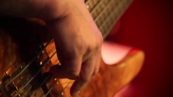 Gitarr körsbär färg på en bakgrund, jazzmusik, bas, energisk gitarrspel, vackra mans händer spelar gitarr, musiker i en rosa skjorta — Stockvideo