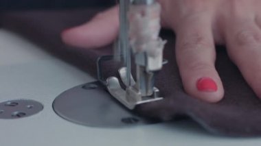 moda, dikiş makinesi, dikiş makinesi için iplik makaraları, makine üzerinde bir kadın eli dikiş, iplik kahverengi