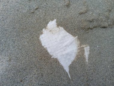 Dökülen desenleri gösteren yırtık beyaz kağıtlı, kaba beton yüzeyin soyut dokulu arkaplanı çürümeyi veya keşfi iletir