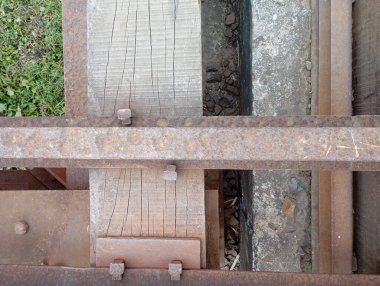 Paslı metal ve ahşap tren yolu çimen arka planlı