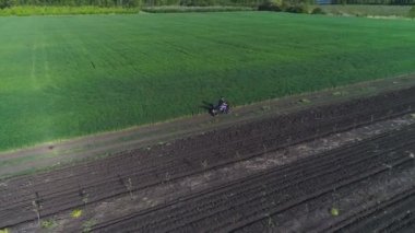 Köy yolunda motosikletli genç bir adam. Tarım alanları