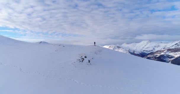 Uma mulher fotografa uma encosta nevada. As coníferas estão cobertas de neve. Nuvens flutuam ao longo do desfiladeiro. picos nevados Turistas nas montanhas do Cáucaso Arkhyz 2020 — Vídeo de Stock