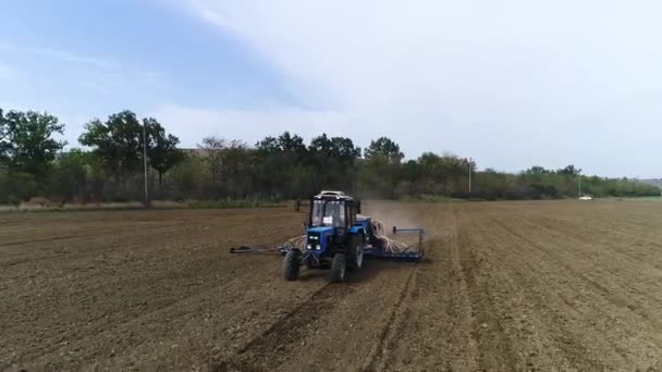 농업용 트랙터가 밭을 관리하면서 씨를 심는다 — 비디오