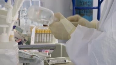 İlacı şırınganın içine çeviriyor. Bir damla için bir şişe tuz çözeltisi. Hazırlık
