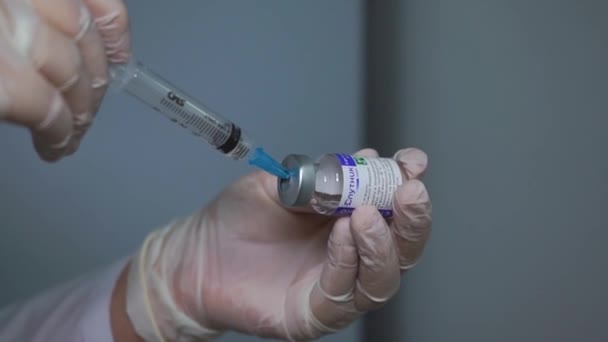 Covid 19 aşısını şişeden çıkaran bir tıp uzmanının yakın plan fotoğrafı. — Stok video