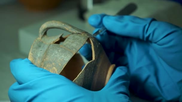 Un arqueólogo en el laboratorio restaura un antiguo jarrón de cerámica hecho a mano — Vídeos de Stock