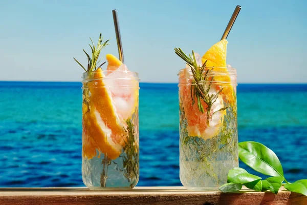 Hard seltzer cocktails, sea on background.
