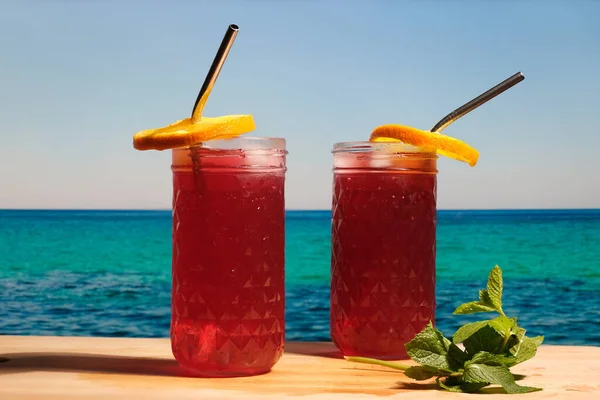 Two rum cocktails with cranberry juice on the tropical beach.