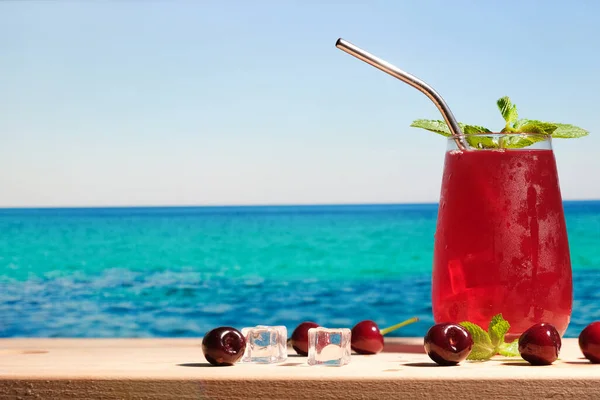 Summer cherry cocktail on the beach.