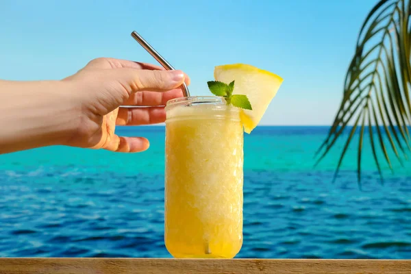 Drinking glass of melon smoothie on tropical beach bar.