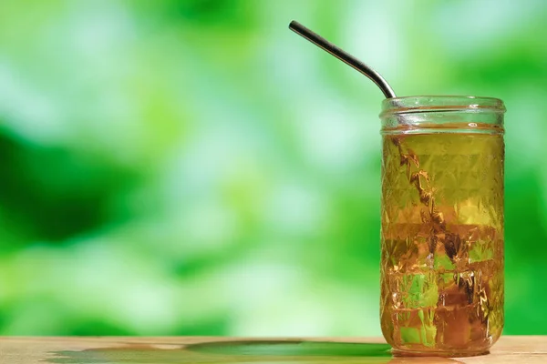 Glass of ice tea outdoors.