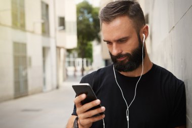 Siyah Tshirt Blank Snapback Cap Yaz Saati Giyen Sakallı Kaslı Adam.Akıllı Telefon Kulaklık Kullanan Genç Adamlar Ekran AlaMetli.Yatay.