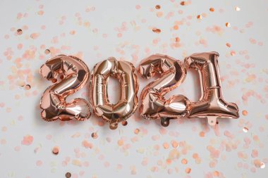 Yeni yıl ve yeni yıl 2021 kutlama konsepti. 2021 numaralı folyo balonları ve pembe arka planda konfeti. Hava Balonları. Tatil partisi dekorasyonu.