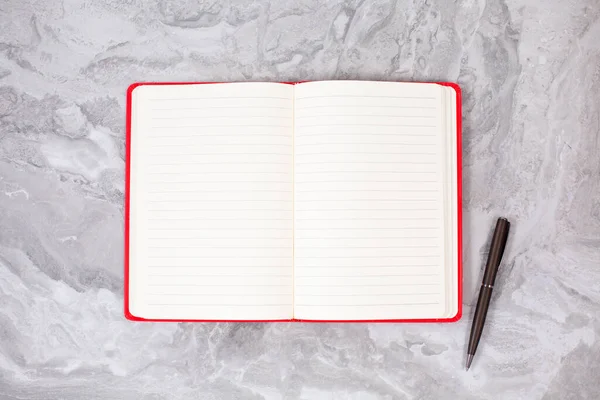 Ανοίξτε σημειωματάριο και μαύρο στυλό σε μαρμάρινο τραπέζι — Φωτογραφία Αρχείου