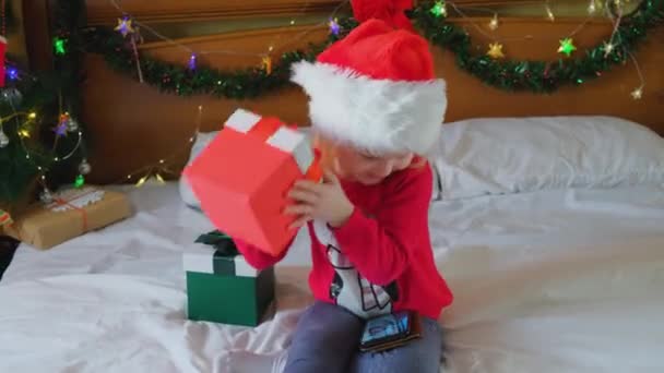 Félicitations en ligne de Noël. Petite fille heureuse utilisant le téléphone mobile — Video