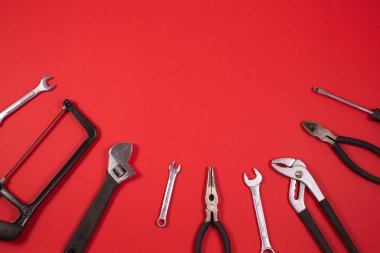 Kırmızı arkaplanda onarım için inşaat araçları.