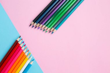 Yaratıcı renkli arkaplanda gökkuşağı parlak renkli kalemler.