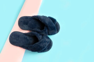 Renkli arka planda mavi ev terlikleri.