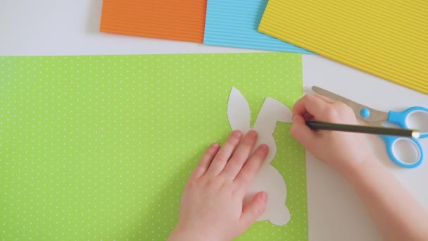 DIY decoração de Páscoa. Mãos de criança Desenhe o esboço de coelho de papel. — Vídeo de Stock