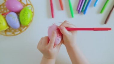 Çocuklar Paskalya yumurtasını kırmızı kalemle boyarlar.