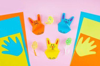 Ellerindeki çocuk avuçlarından renkli kağıt tavşanlar.