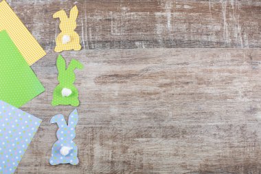 Renkli Paskalya kâğıdı tavşanlar, tahta masa üzerinde kuyruğu olan tavşanlar..