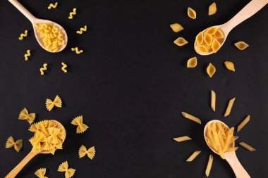 Masadaki tahta kaşıklarda farklı makarna tipleri..