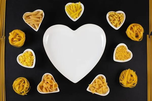 Pasta-Auswahl rund um herzförmige Porzellanschalen — Stockfoto