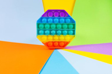 Stres önleyici oyuncağı patlat. Renkli arkaplanda gökkuşağı silikon duyusal kıpırtı.