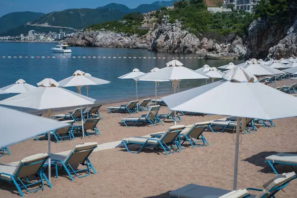 Порожні білі шезлонги без людей під парасолькою гальковий пляж біля моря . — стокове фото