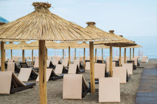 Порожні білі шезлонги без людей під парасолькою гальковий пляж біля моря . — стокове фото