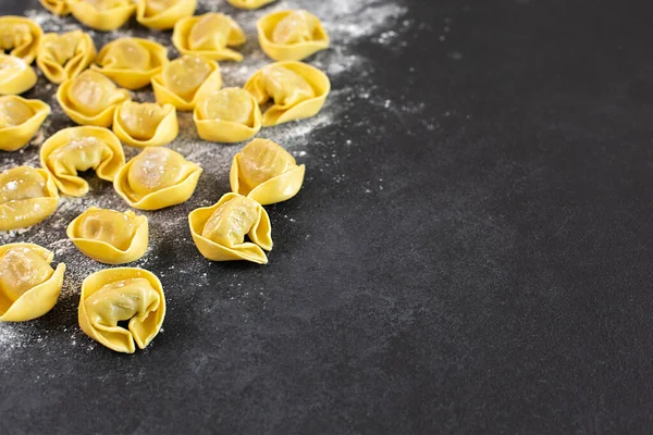 Ungekochte Tortelloni mit Pilzfüllung auf schwarzem Hintergrund, — Stockfoto